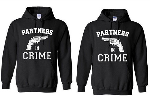Matching sweaters with handguns pointed at each other. "Partners in crime.'