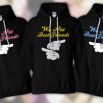three matching sweaters say "we are best friends," with center sweater pointing at the other two