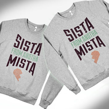 Matching sweaters say "Sista from anotha mista"